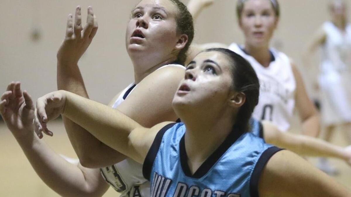West Johnston’s Kira Byrd (11) and Smithfield-Selma’s Jada Billups (33) battle each other for a rebound under the basket.