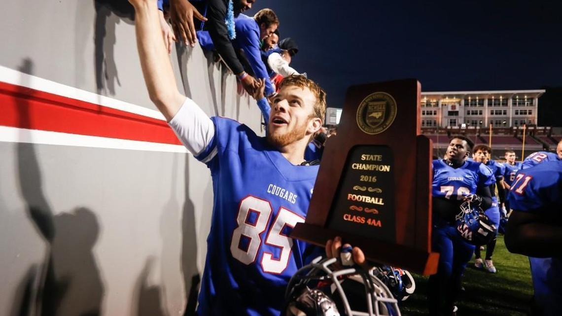 Wake Forest senior wide receiver Josh Vaughn (85) carries the championship trophy to the locker room as he celebrates with fans along the way following the NCHSAA 4AA football championship game between Greensboro Page and Wake Forest in Raleigh on Saturday, December 17, 2016. Wake Forest won the game 29-0.