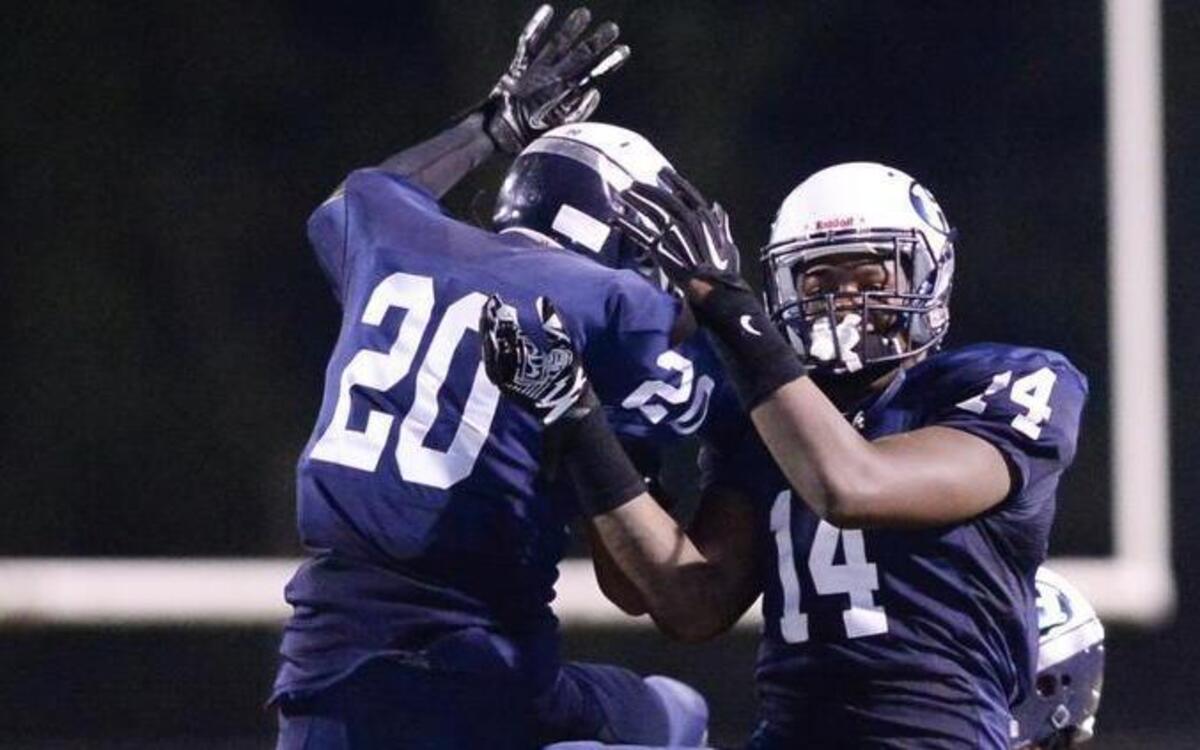Najee Reams (20) and Daeshawn Stephens (14) of Hillside celebrate a defensive win during the second half. The Hillside Hornets played the Cardinal Gibbons Crusaders in Durham, N.C. on Friday, October 9, 2015. Hillside won 41-8.