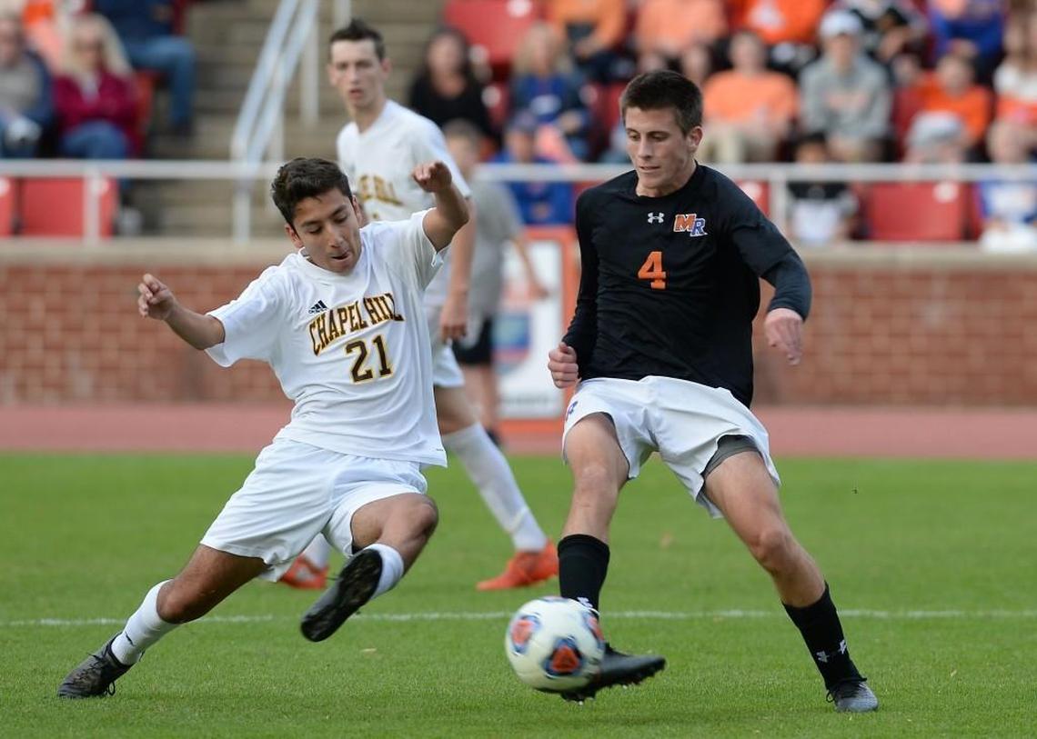 Richard Vaca (21) of Chapel Hill slides for a tackle against Hayden Green (4) of Marvin Ridge. The Chapel Hill Tigers played the Marvin Ridge Mavericks in a men soccer game that counted for the NCHSAA 3A State Championship and took place at the N.C. State University Dail Stadium in Raleigh, N.C. on Saturday, November 19, 2016. Marvin Ridge won 1-0.