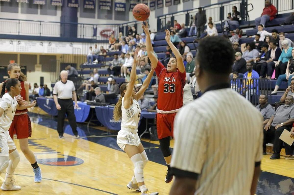 Northwood Temple Academy's Kendal Moore (15) defends as Neuse Christian Academy's Izabela Leite Nicoletti (33) shoots the three pointer. The Neuse Christian Academy Lions and Northwood Temple Academy Eagles girls and Greenfield Knights and Trinity Christian School Crusaders boys played at Forsyth Country Day School in the NCISAA Class 1A Final basketball tournament championships on Feb. 24, 2018.