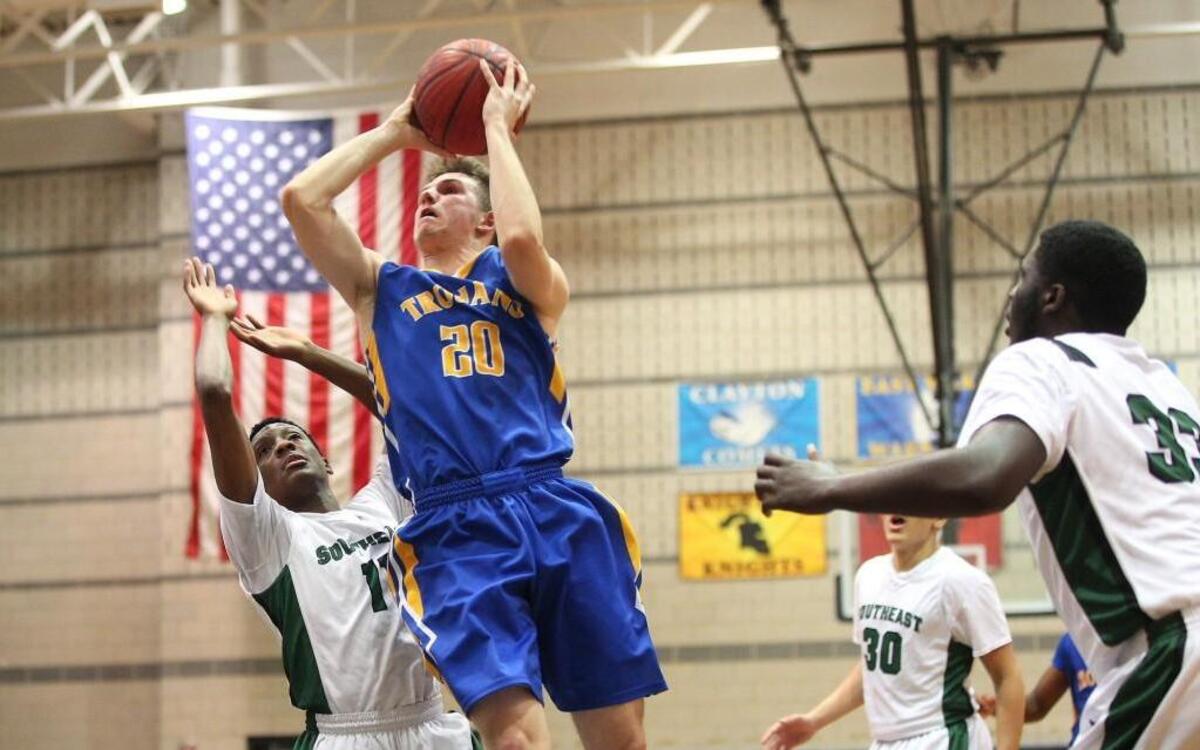 Garner’s Nick Kuhns (20) lays against Southeast Raleigh's John Baker Iv (11) as he shoots during the Garner Magnet Trojans high school basketball game against the Southeast Raleigh Bulldogs, January 21, 2016, in Raleigh, N.C. Garner won the game 101 -61.