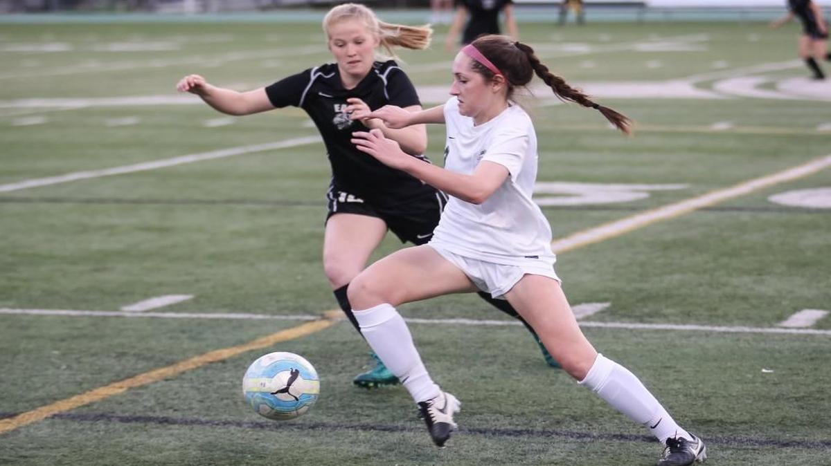 Cardinal Gibbons' Meghan Kast, right, changes direction and turns upfield as East Chapel Hill defender Caelan DeMuth (12) closes during East Chapel Hill's soccer game at Cardinal Gibbons on Monday, April 10, 2017. Cardinal Gibbons won the game 7-2.