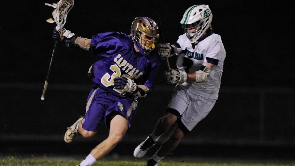 Broughton’s Nick Cattano (32) runs past Leesville Road's Tyler Beebe (7) in Raleigh, N.C. on Tuesday, March 1, 2016. Broughton won 12-8.