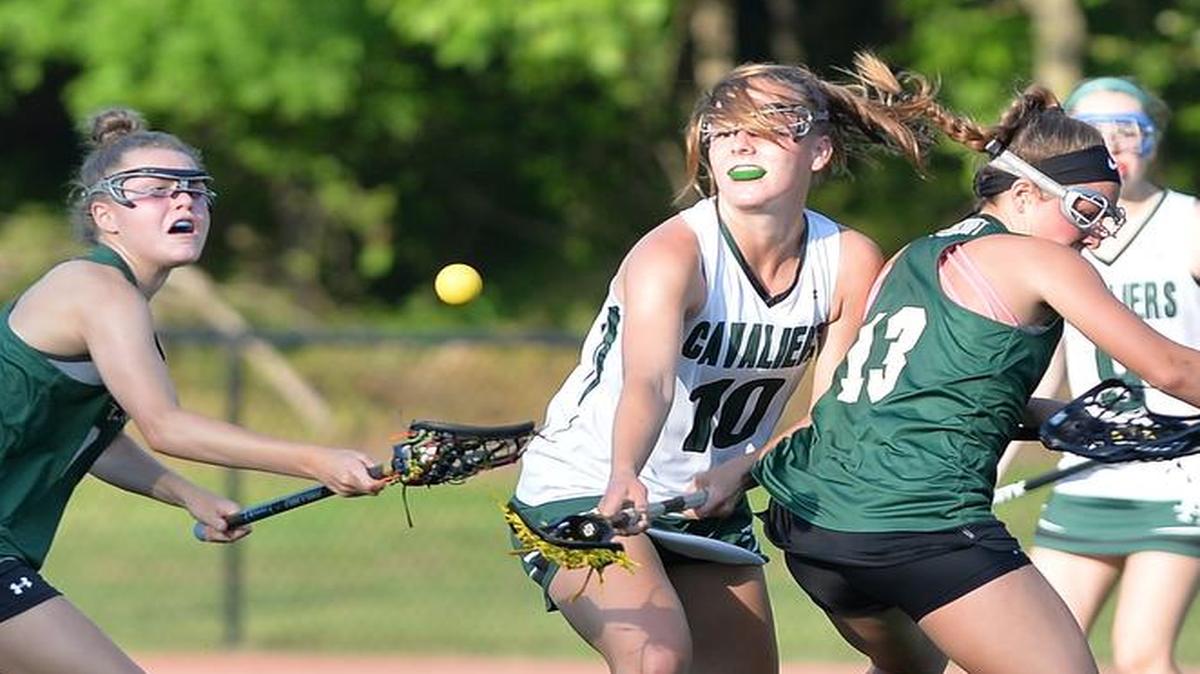 Madi Dunk (10) of Durham Academy fights for control of the ball against Brooke Baker, left, and Camryn Fletcher (13) of Ravenscroft. The Durham Academy Cavaliers played the Ravenscroft Ravens in a girls lacrosse game that took place in Durham, N.C. on Friday, April 28 2017. Durham Academy won 12-11 in overtime.