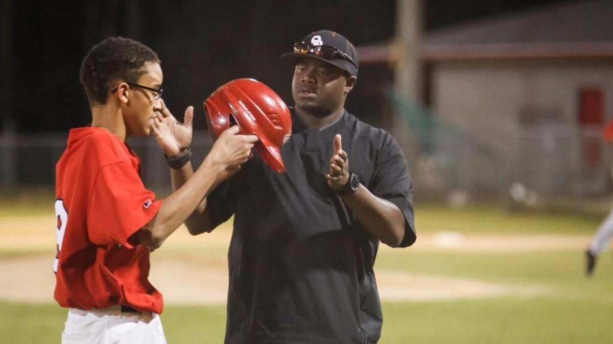 Southern head coach Avery Bryant takes the helmet from one of his players during Hillside's baseball game at Southern Durham on Thursday, March 9, 2017. Hillside won the game 20-4.