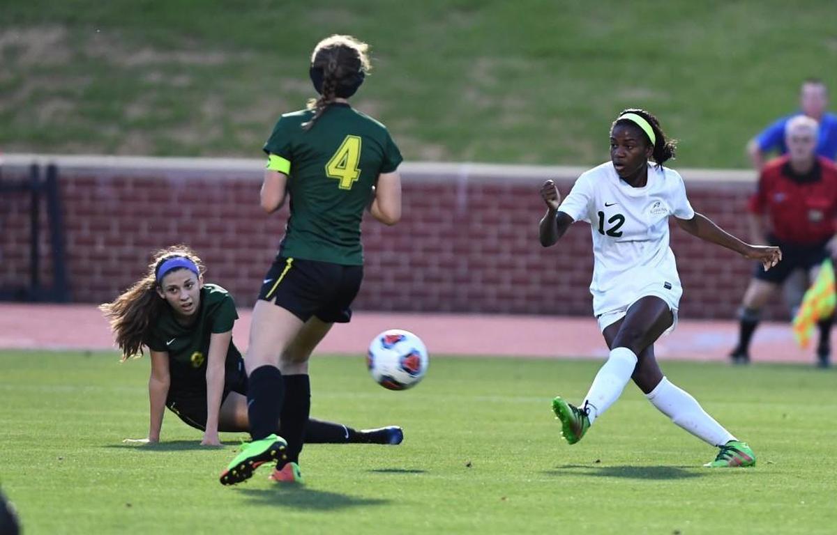 Taylor Currie (12) of Cardinal Gibbons takes a shot on goal against Riley Terry, left, and Delaney Cowart (4) of West Forsyth. The Cardinal Gibbons Crusaders played the West Forsyth Titans in a soccer game that took place in Raleigh, N.C. on Saturday, May 27 2017. West Forsyth won 4-3.