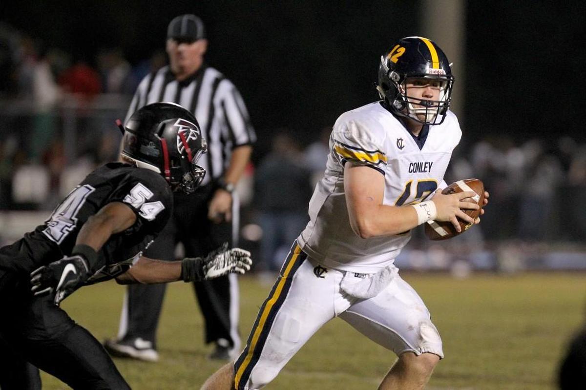 D.H. Conley's Holton Ahlers (12) with the scramble as South Central's Josh Stevens (54) attempts to tackle. The D.H. Conley Vikings visited the South Central Falcons in a high school football game on Nov. 3, 2017