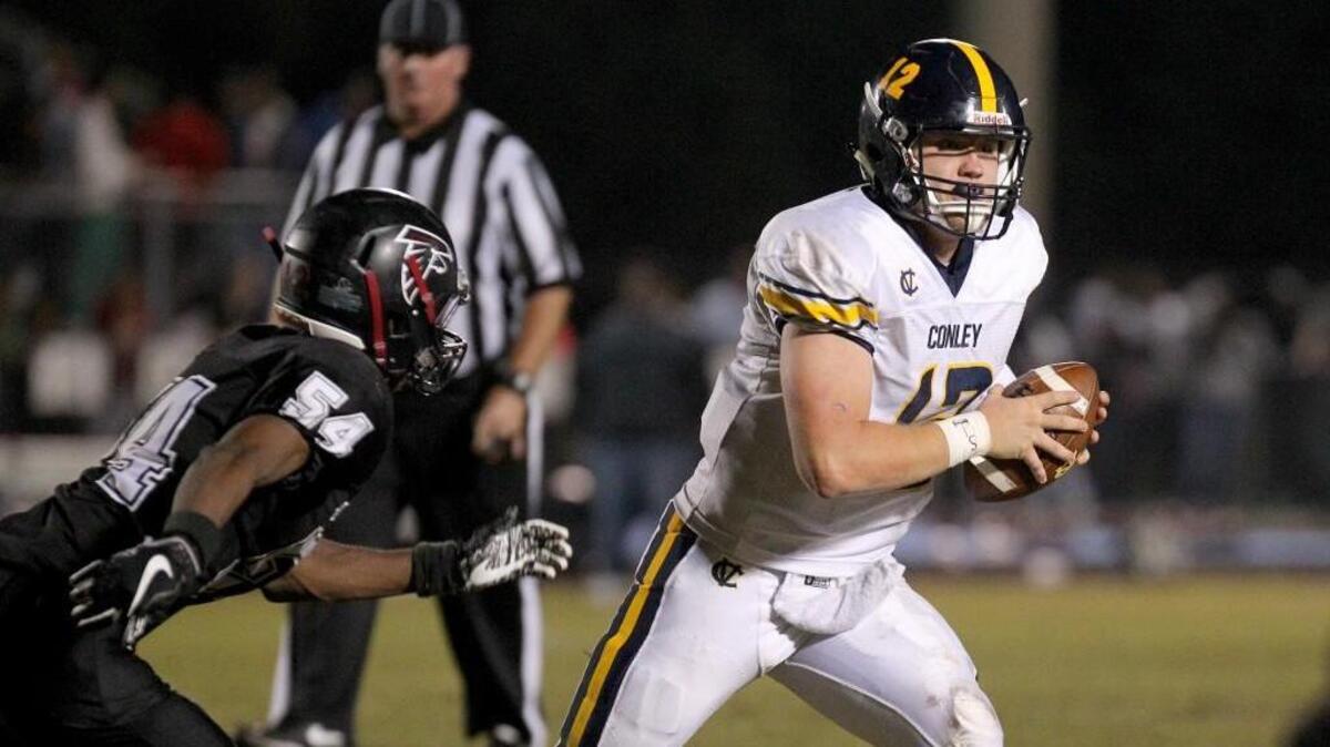 D.H. Conley's Holton Ahlers (12) with the scramble as South Central's Josh Stevens (54) attempts to tackle. The D.H. Conley Vikings visited the South Central Falcons in a high school football game on Nov. 3, 2017