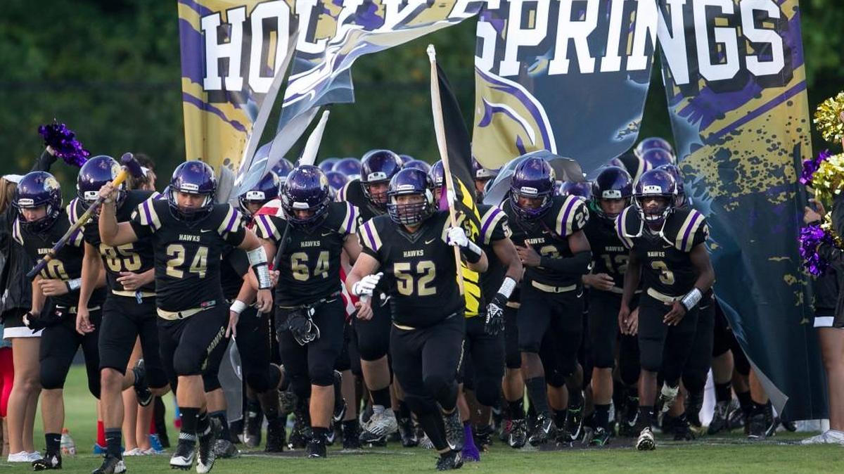 
Holly Springs’ Davis Strafford (24) and Jason Gerber (52) lead their team on to the field for their game against Green Hope on Friday, September 11, 2015 in Holly Springs, N.C.
