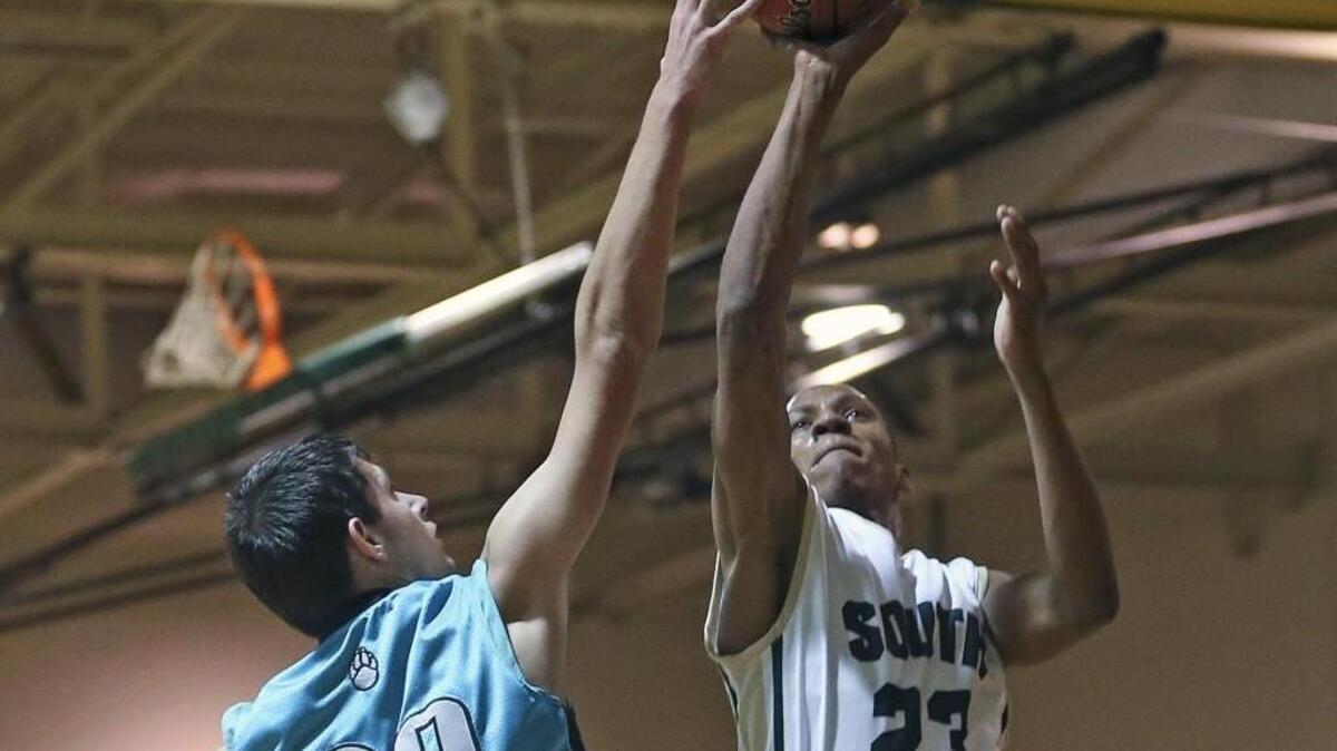 South Johnston’s Javonte Smith (23) gets a shot off but West Johnston’s Wade Eatmon (20) is able to get a hand on the ball.