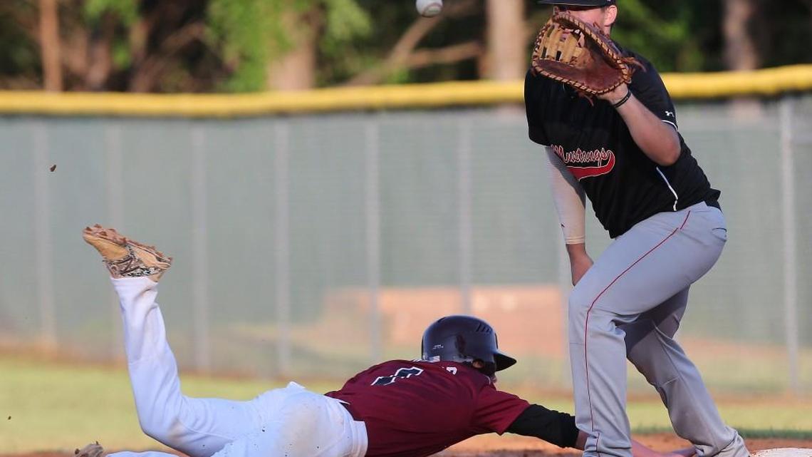 Green Hope's Connor Knapp (1) dives to first as Middle Creek's Trevor Heasley (7) waits on the ball during the Middle Creek Mustang High School baseball game against the Green Hope Falcons on May 4, 2016, in Cary, N..C. Green Hope won 2-0.