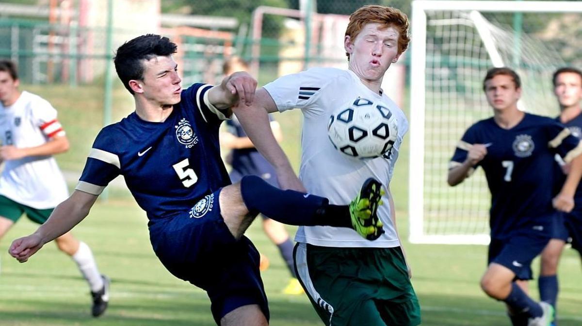 
St. David's School's Jose Cornejo (5) boots the ball in front of Ravencroft's Alex Lindsay during the boys soccer game in Raleigh on September 9, 2015. Ravenscroft won the match 2-0.
