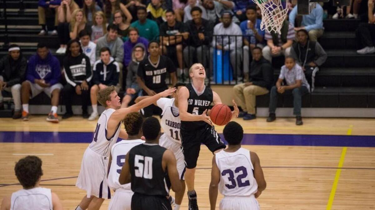 Cedar Ridge’s Peyton Pappas (5) goes for a layup amid Carrboro defenders, left to right, Cole Phillips, JaNyAlston, Max Mahadevan and Noah Jones.