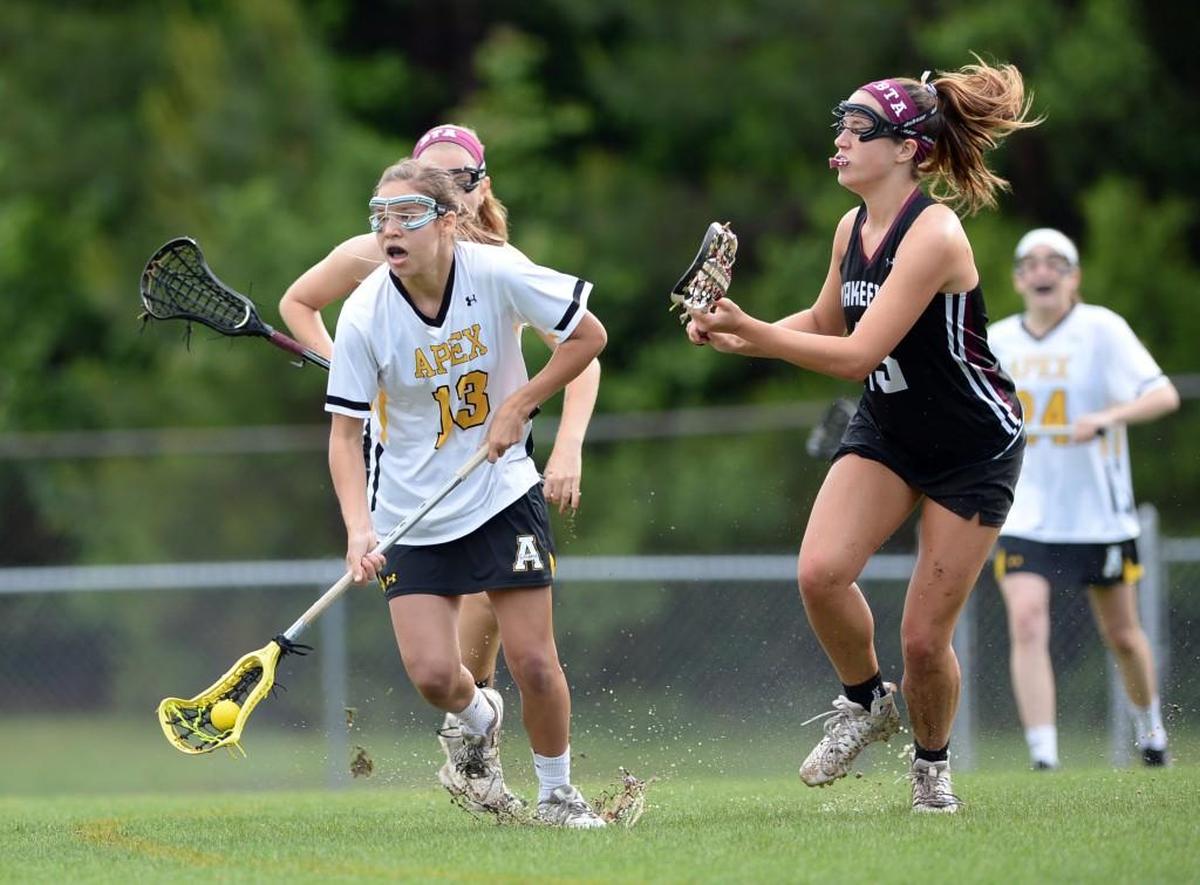 Ellie Bromley (13) from Apex moves the ball against Wakefield's Julie Ann Pretty (#15). Apex Cougars played the Wakefield Wolverines in the girls LAX game which was played in Apex on Friday, May 7, 2016. Wakefield won 16-8.