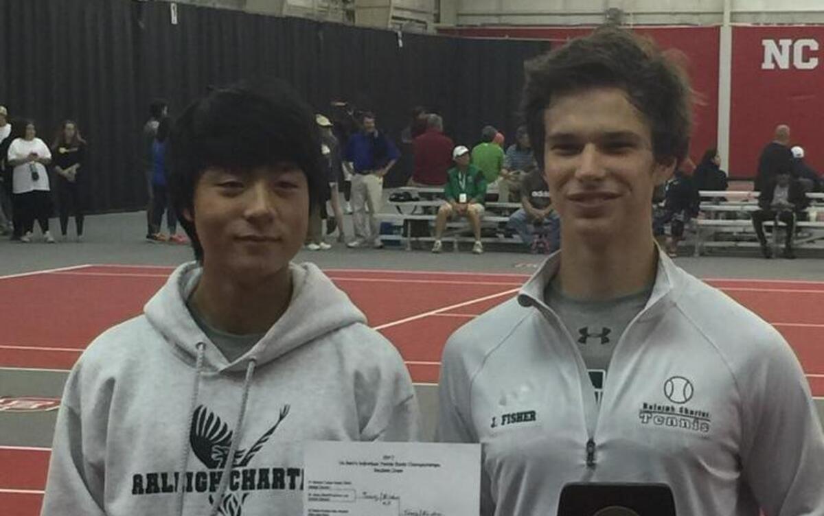 Raleigh Charter's Harrison Tseng, left, and Joseph Fisher, right, pose with the 1A doubles bracket and championship trophies at the NCHSAA individual boys tennis championships at N.C. State on May 13, 2017.
