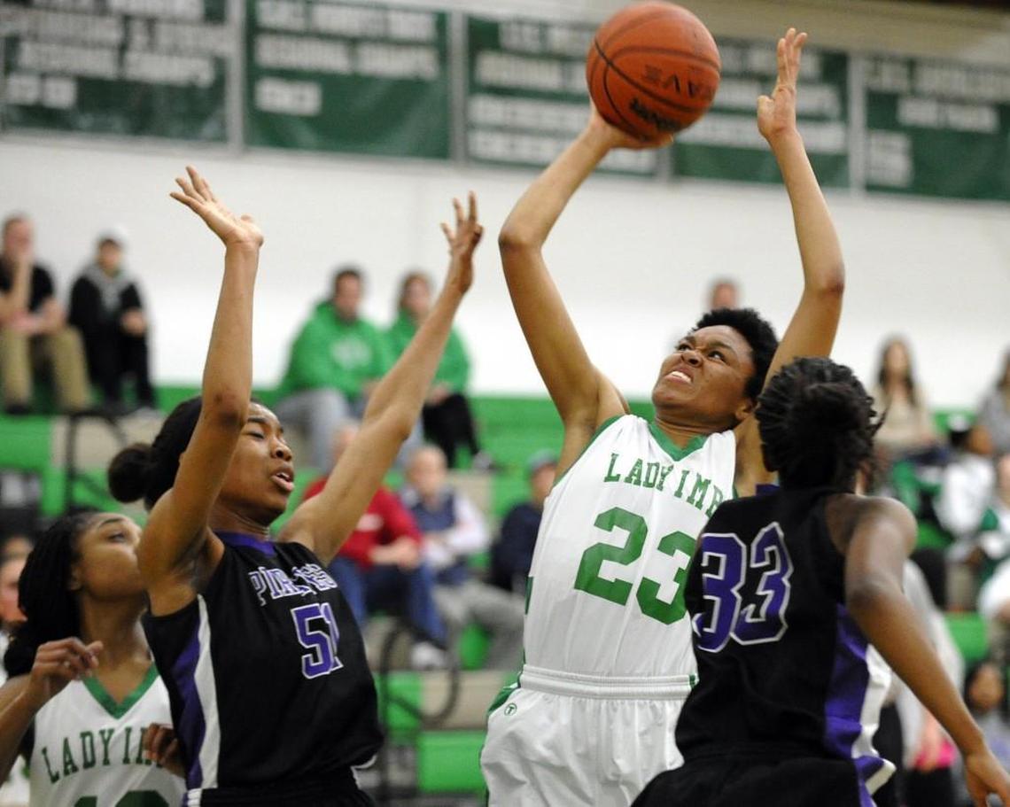 Cary's Azura Stevens (23) shoots between Riverside's Mone Jones (left) and Kiara Jacobs during the girls basketball game in Cary on Wednesday, February, 26, 2014. Riverside won 70-62.