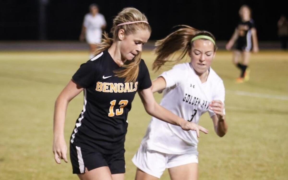 Fuquay's Maddie Smith (13) dribbles while being pressured by Holly Springs' Ava Slovensky (3) during Fuquay-Varina's soccer match at Holly Springs on Wednesday, March 8, 2017. Holly Springs won the game 3-0.