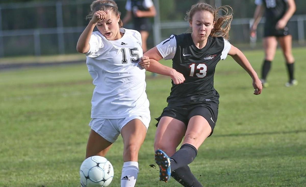 Middle Creek's Mattie Murphy slips this shot past Wakefield's Sierra Lowery (15) and into goal to put the Mustangs up 2-0 midway through the first half. Coverage from 2nd round of the 4A NCHSAA Girls Soccer playoffs between the Middle Creek Mustangs and the Wakefield Wolverines played in Raleigh, N.C. on Saturday, May 13, 2017. Middle Creeks defeats Wakefield 2-1 to advance to the third round of the playoffs.