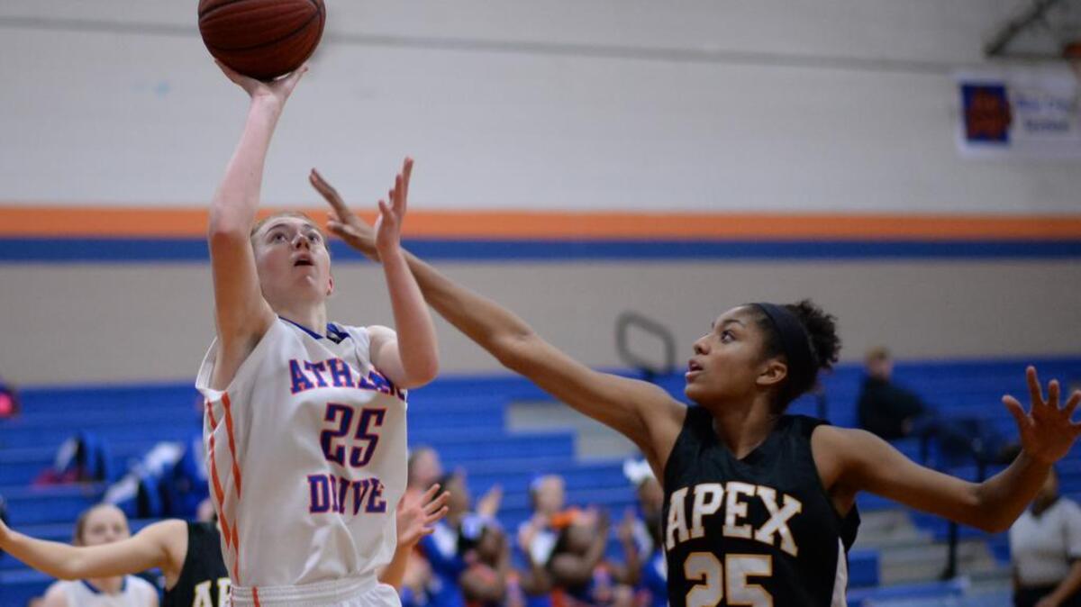 Robin Gallagher (25) of Athens Drive scores a 2-point basket against Samantha Michel (25) of Apex. The Athens Drive Jaguars played the Apex Cougars in a girls basketball game that took place in Raleigh, N.C. on Friday, January 15, 2016. Athens Drive won 67-54.