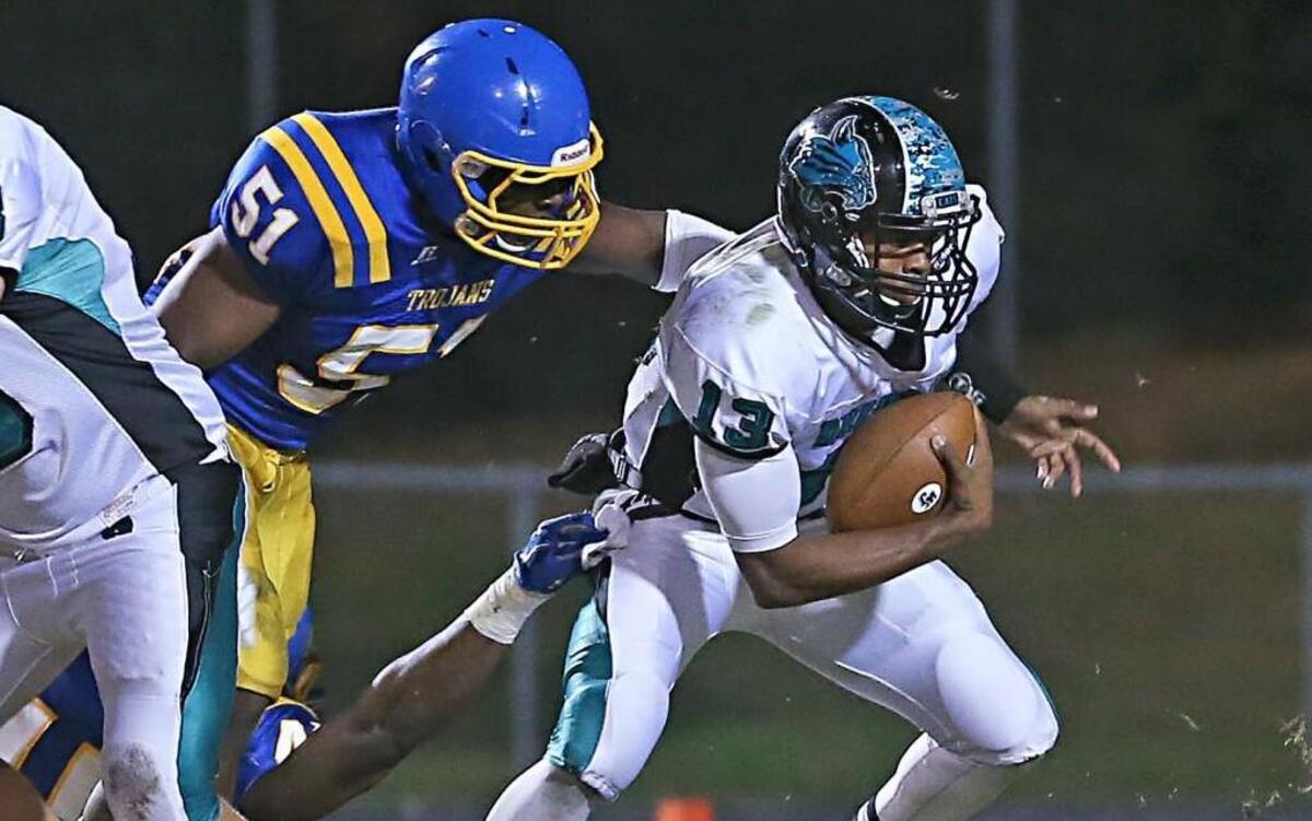 Garner’s Joe Spinks sacks West Johnston's Andre Wilson (13) for a loss early in the game. Coverage from the high school football game between the Garner Trojans and the West Johnston Wildcats played in Garner, N.C. on Friday, October 30, 2015. Garner leads at the half 14-0.