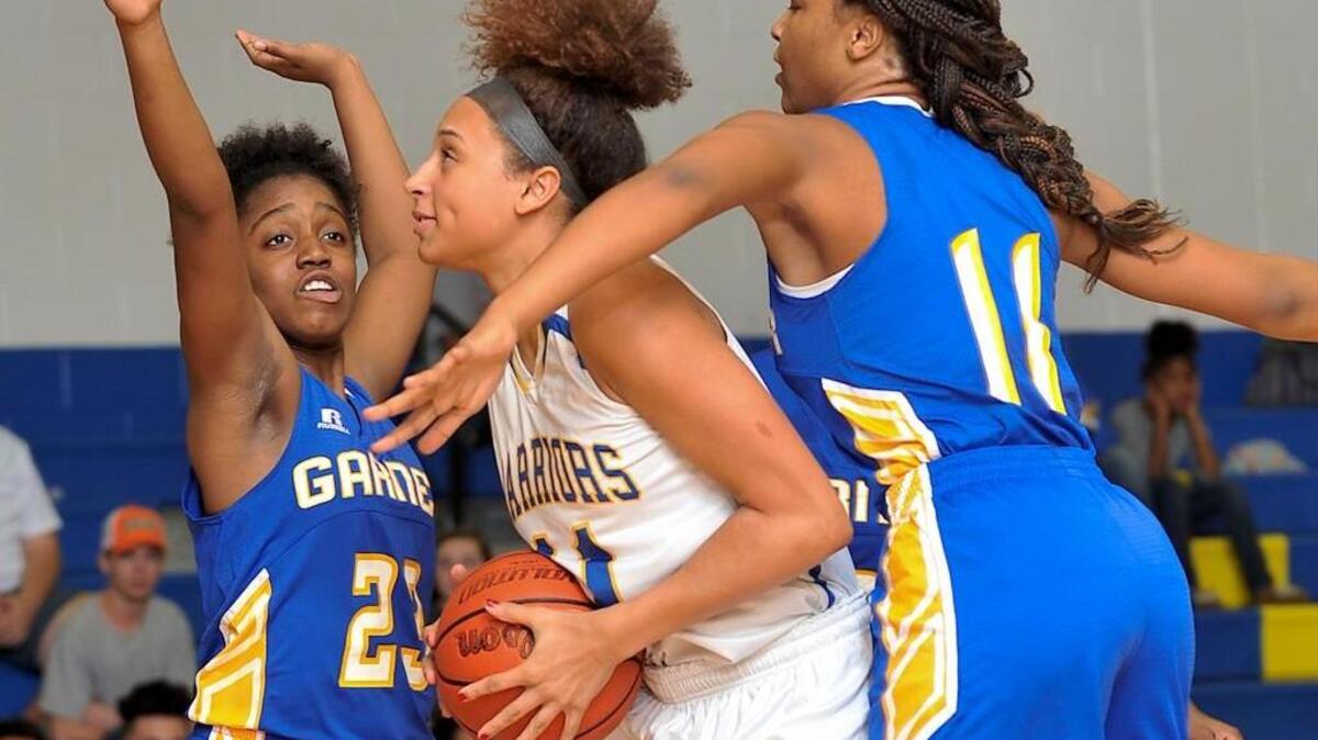 East Wake’s Angel Rizor (11) looks to shoot while guarrded by Garner's Mya Williams (11) and Kennedi Coates (23). The East Wake Lady Warriors took on the Garner Lady Trojans in basketball in Wendell, N.C. on December 11, 2015. East Wake won 72-26.
