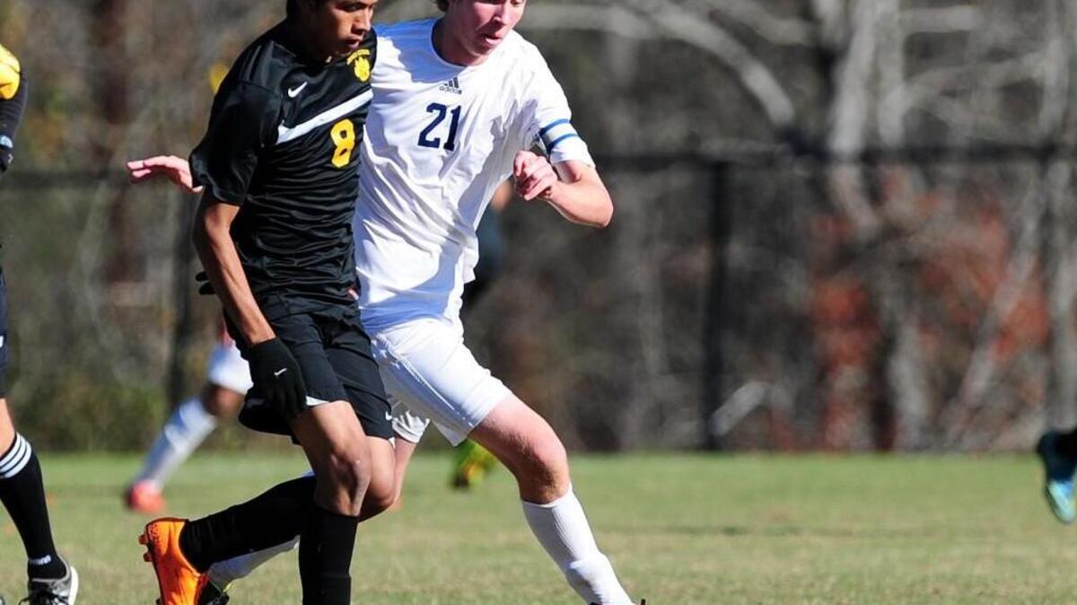 Franklin Academy's Nick Hughes (21) and James Kenan's Bersain Gonzalez (8) battle for the ball during the NCHSAA 1A boys soccer fourth-round play-off game, which was played on Saturday, November 14, 2015 in Wake Forest. Franklin Academy won 2-1.