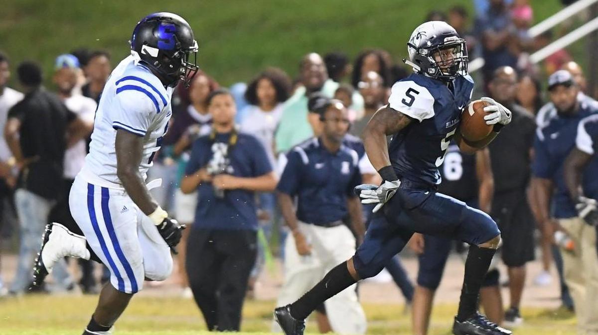 Jamal Elliott-Currie (5) of Hillside carries the ball against the pursuit of Chris Williams, left, of Scotland. The Hillside Hornets played the Scotland Fighting Scots in a football game that took place in Durham, N.C. on Friday, August 26 2017. Scotland won 34-21.