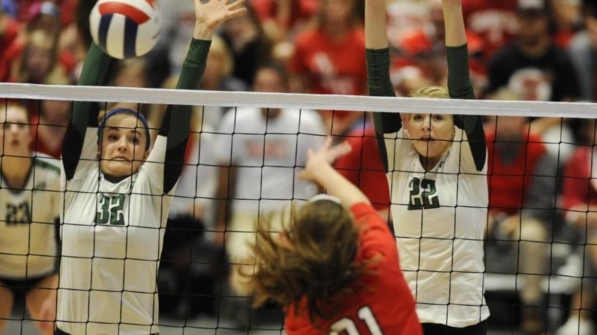 Cardinal Gibbons’ Christine Merdes (32) and Emma Longley (22) try to block a hit by Northwest Guilford's Kaitlyn Grube (21) in Raleigh, N.C. on Saturday, November 7, 2015. Cardinal Gibbons won to become the Class AAAA State Champions.