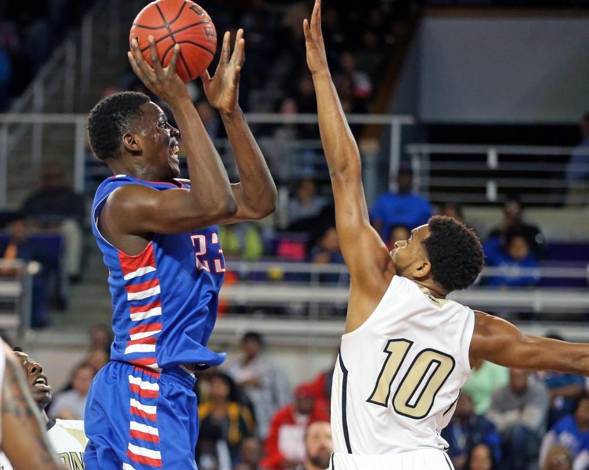 Greene Central's Imajae Dodd (23) puts a shot up over Clinton's Tymair McIntyre (10). The Greene Central Rams and the Clinton Dark Horses played in the 2A boys 2A Eastern Regional basketball finals at East Carolina University on Saturday, March 3, 2018.