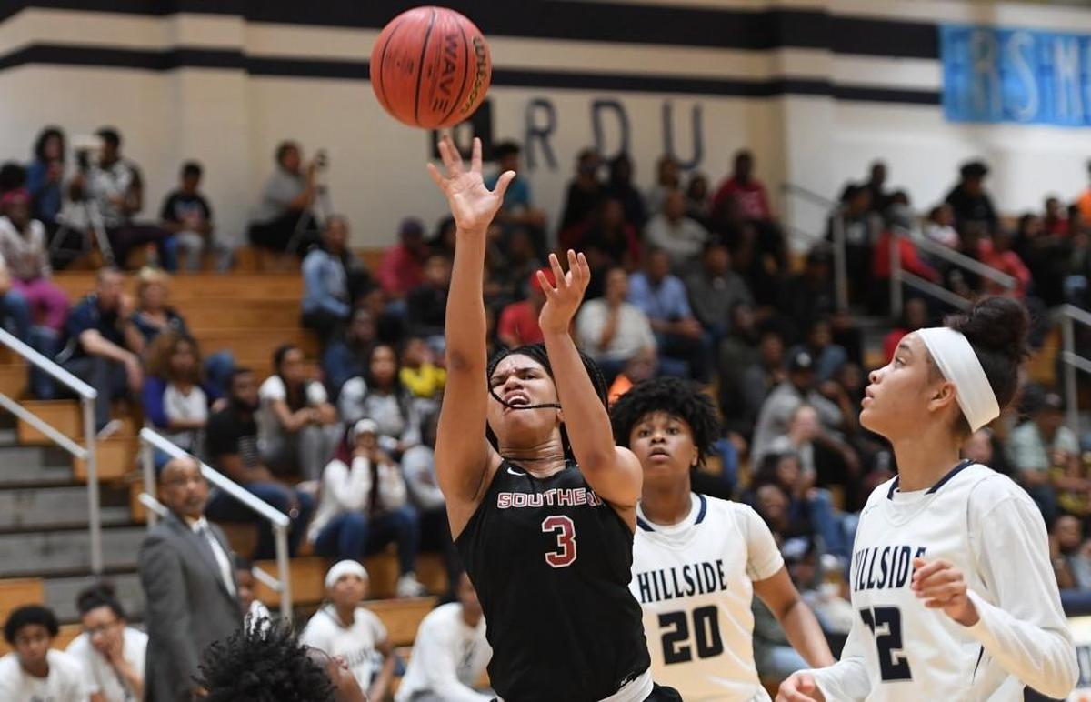J'Naya Ephraim (3) of Southern Durham drives with a layup against Maliyah Sparrow (20) and Faith Blackstone (12) of Hillside. The Hillside Hornets and the Southern Durham Spartans played in the Big Eight 3A Conference girls basketball tournament championship on Feb. 16, 2018.
