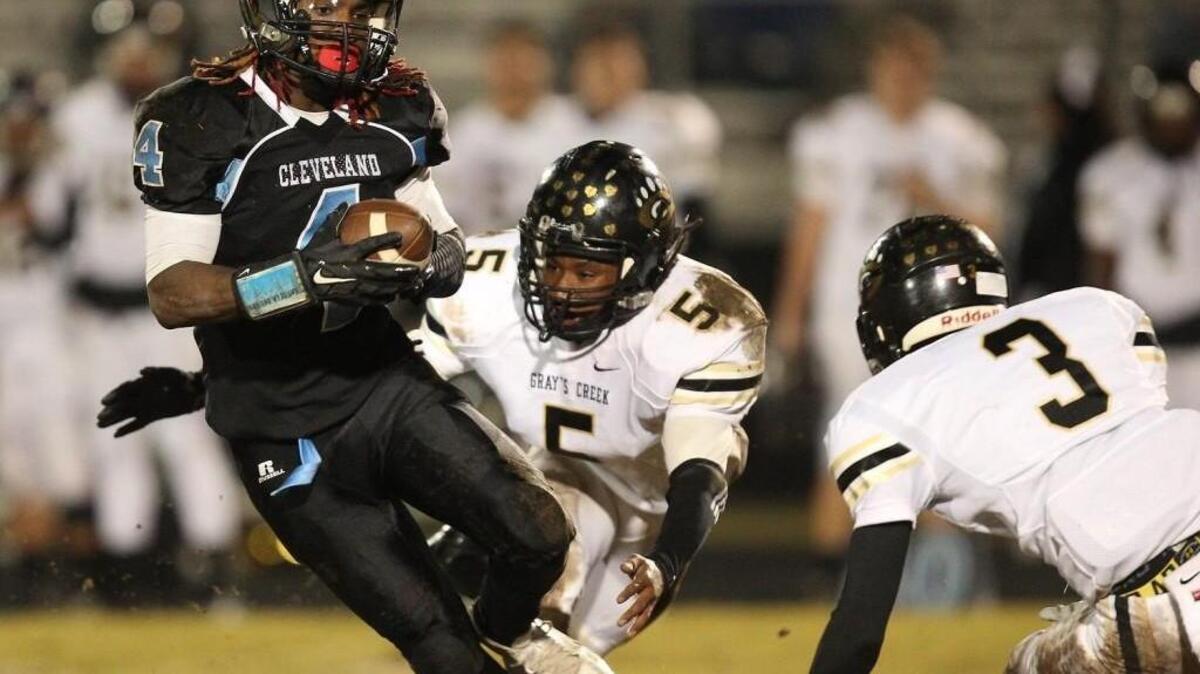 Cleveland’s Patrick Jesequel (5) runs away from Gray's Creek Ja-myri Casimir (5) during the Hope Mill's Gray's High School football game against Cleveland High School Friday, November 20, 2015, in Clayton, N.C.Cleveland won the game 36-18.