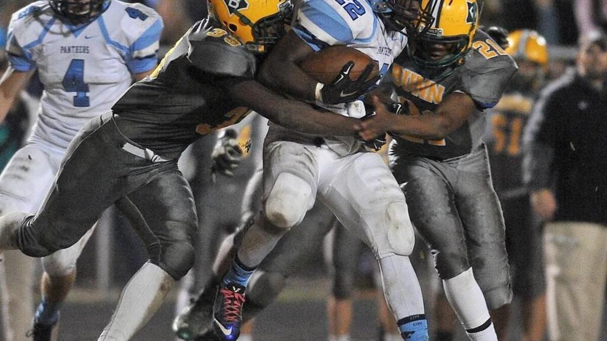 Bunn’s Celik Curtis (33) and Deaundra Moses (21) grapple East Duplin’s Tyran Outlaw (22).