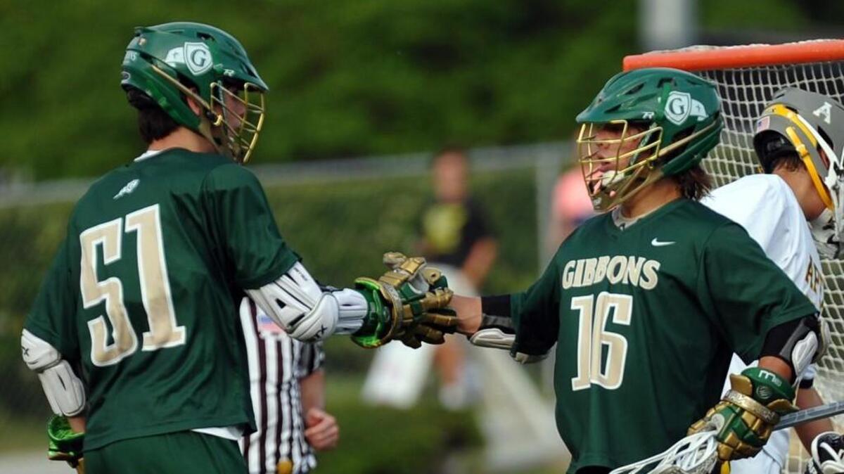 Cardinal Gibbons' Adam Barry (51) and Jack Shelton (16) celebrate a goal against Apex during the boys lacrosse game, which was played in Apex on Tuesday, May 10, 2016. Cardinal Gibbons won 8-6.