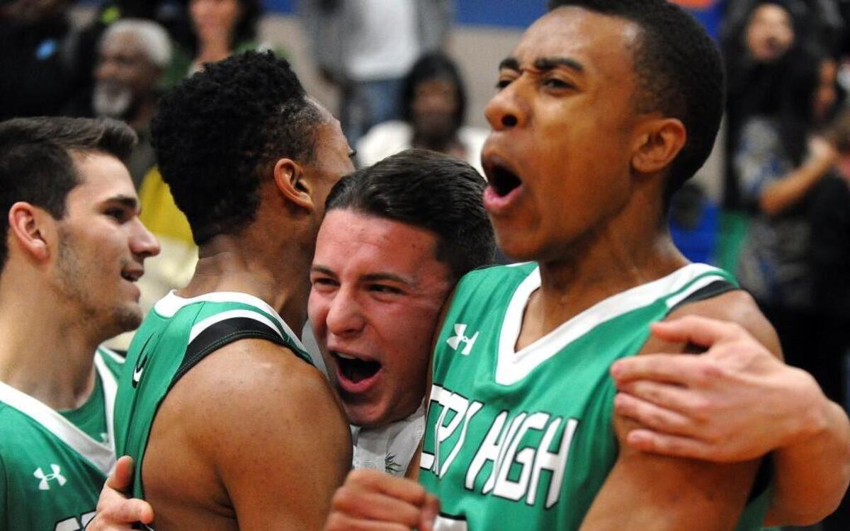 Cary's Elijah Idlett (right) celebrates their overtime win with teammates and fans after the basketball game against Athens Drive, which was played in Raleigh on Thursday, December 15, 2016. Cary won 57-56 in overtime.