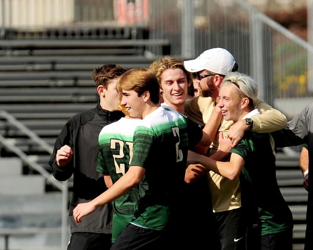 Cardinal Gibbons celebrates winning the NCHSAA 4A Mens Championship soccer game with coach Tim Healy (white cap). The Cardinal Gibbons Crusaders beat the Hough Huskies 2-1 in the NCHSAA 4A mens soccer championship game, November 18, 2017 in Raleigh.