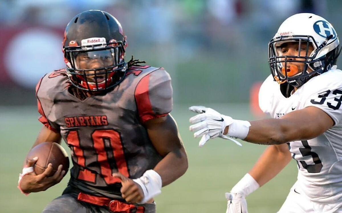 
Jordon Brown (10) of Southern carries the ball against Traevon Hayes (33) of Hillside. The Hillside Hornets played the Southern Spartans at the North Carolina Central University, O'Kelly-Riddick Stadium, in Durham, N.C. on Friday, September 4, 2015. 

