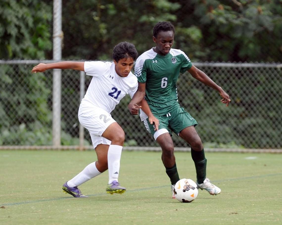Raleigh Charter's Sayak Basu (21) and Research Triangle's Jadyn Asamoah (6) battle for the ball during the boys soccer game, which was played in Cary on Wednesday, October 5, 2016. Raleigh Charter won 5-1.