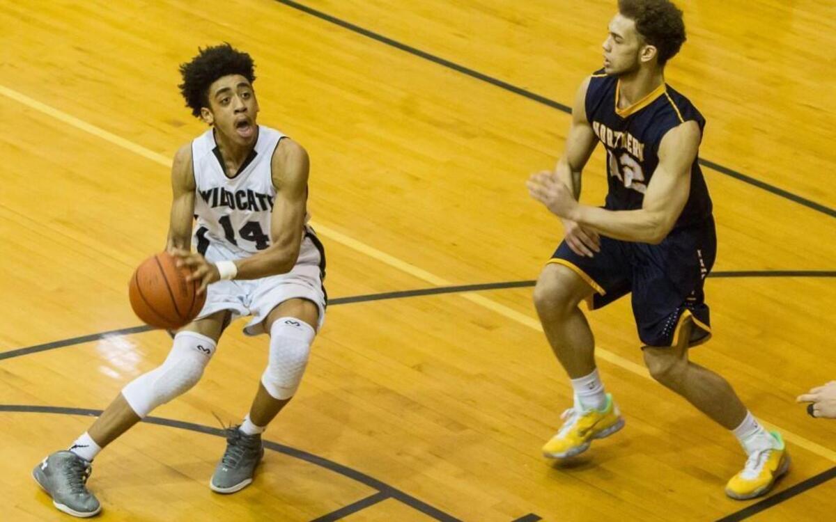 East Chapel Hill’s Carter Collins (14) looks for a shot against Emmett Tilley (12) during their PAC-6 basketball game Friday, Feb. 5, 2016, at Wildcat Gym in Chapel Hill.