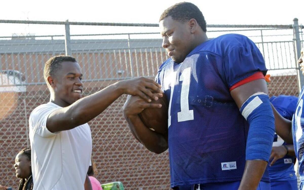 
Brothers Devon, left, and Dexter Lawrence kid around during a water break at Wake Forest’s football practice on August 13, 2015. Dexter is #1-ranked player in the nation, a 6-foot-4, 330-pound defensive lineman. Devon is a sophomore running back and just 5-10, 180 pounds, but is also one of the best in his class. Devon had a minor injury and wasn't practicing this day.
