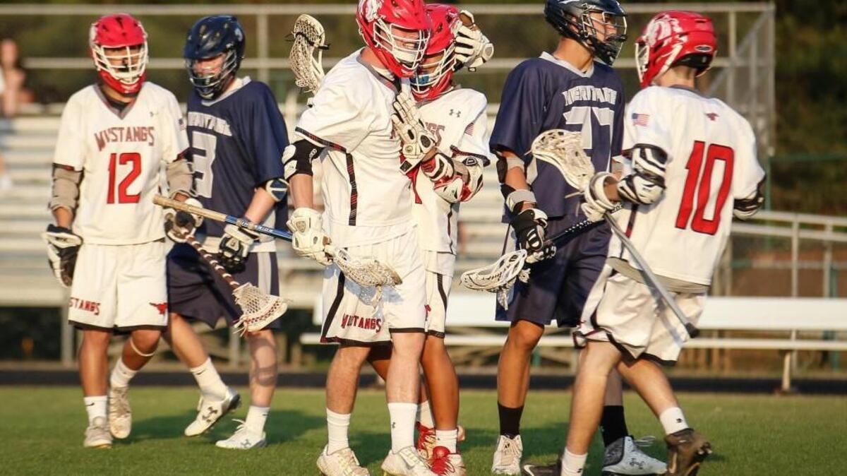 Middle Creek's Nate Post (11), left, celebrates with teammate David Baird (31) after scoring a goal during Heritage's boys lacrosse game at Middle Creek on Tuesday, May 10, 2016. Middle Creek won the game 17-5.