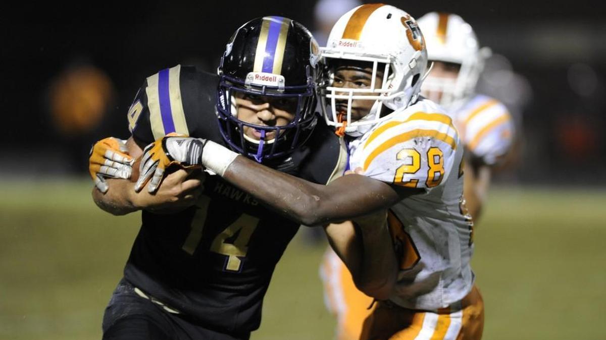Holly Springs' Broderick Taylor (14) is tackled by Fuquay-Varina's C.J. Scales (28) in Holly Springs, N.C. on Friday, September 30, 2016. Holly Springs won 23-14.