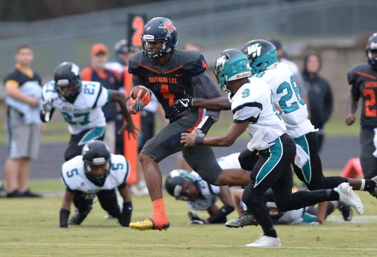 Nate Thompson, center, of Southern Lee carries the ball against the pursuit of Jimmie Gist (9) and Jeffroe McAlister (28) of West Johnston. The Southern Lee Cavaliers played the West Johnston Wildcats in a football game that took place in Sanford, N.C. on Thursday, August 31 2017.