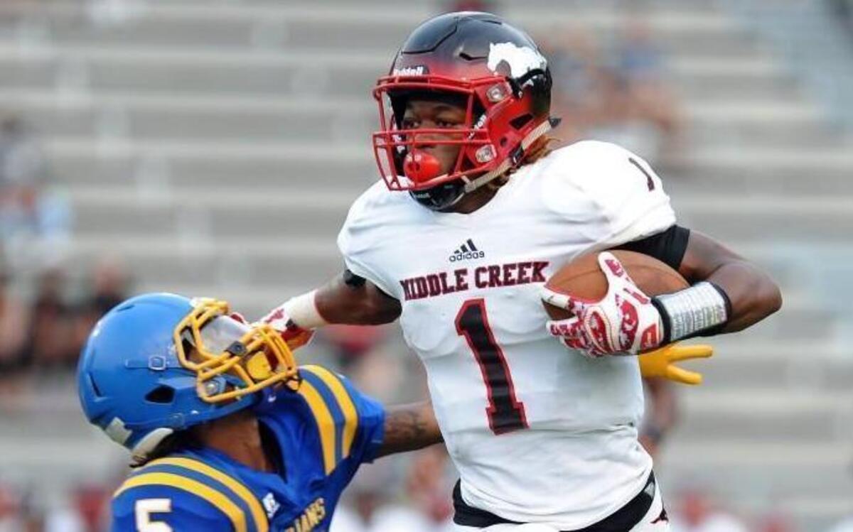 
Middle Creek’s Johnathan Spencer (1) stiff arms Garner's Gregory Harris-Bunn as he gains yards during the football game on Friday, September 4, 2015 in Garner.
