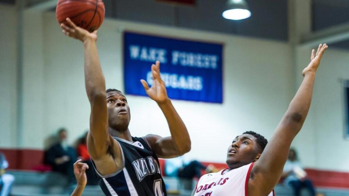 Millbrook’s Faison Brock (4) takes a shot over Wake Forest's Xach Gill (33) during a boys basketball game on Tuesday, December 15, 2015 in Wake Forest, N.C. The Millbrook Wildcats won 84-37.