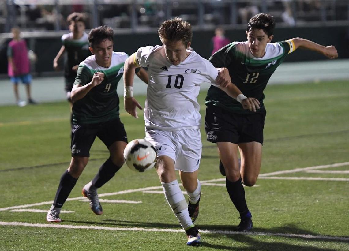 Trevor Berk (10) of Heritage dribbles against Adam Trickett (12) and Martin Mezera (9) of Cardinal Gibbons. The Heritage Huskies visited the Cardinal Gibbons Crusaders in the Wake County Cup championship high school soccer game on Sept. 23, 2017.