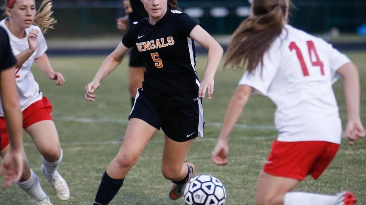 Fuquay's Abigail Burke (5) dribbles through traffic as Middle Creek's Cara Benson (2) and Elizabeth Key (14) close in during Fuquay-Varina's girls soccer game at Middle Creek on Wednesday, April 27, 2016. Fuquay-Varina won the game 3-2.