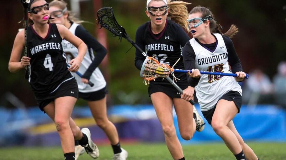 Broughton’s Margaret Ann Warner (18) runs with the ball as Wakefield’s Hanna Anderson (12) and Wakefield’s Megan Blawas (4) trail during a high school lacrosse game in Raleigh, N.C. on Wednesday, Apr. 6, 2016.
