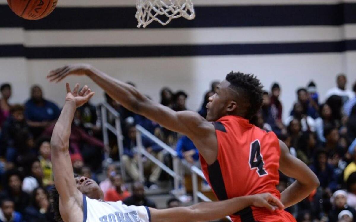 Omri Moore (4) of Southern Durham blocks a shot from Xavier Young (3) of Hillside. The Hillside Hornets played the Southern Durham Spartans in a men basketball game that took place in Durham, N.C. on Saturday, December 10, 2016. Southern won 68-56.