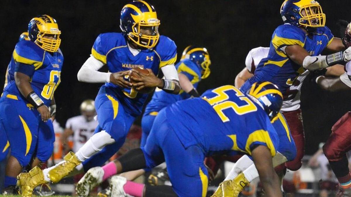 East Wake quarterback Tripp Harrington (3) lunges forward for a first down in the Warriors’ game against Harnett Central at East Wake High School in Wendell, N.C. Friday, Nov. 6, 2015.